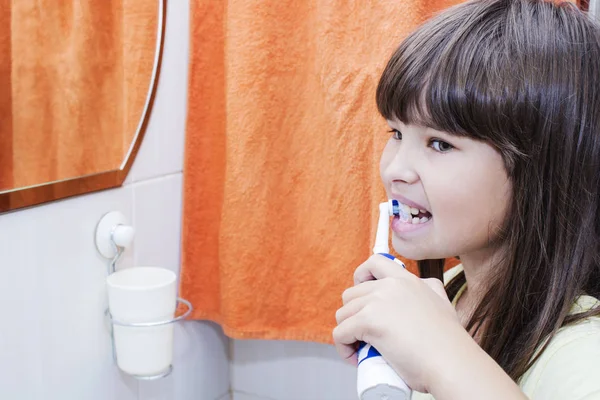 Egy gyerek lány foga fogmosás a fürdő szoba — Stock Fotó