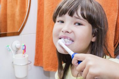 Bir banyo dişlerini fırçalama bir çocuk kız