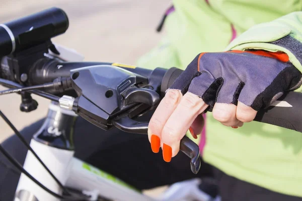 Dames hand met lichte nagellak op de fietswiel. — Stockfoto