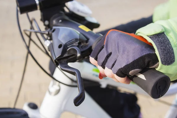 Dames hand met lichte nagellak op de fietswiel. — Stockfoto