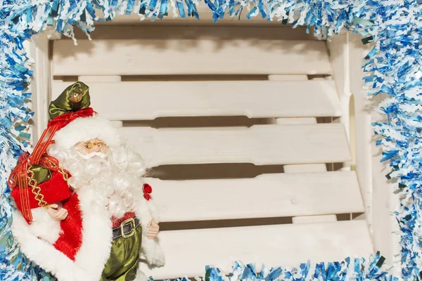 Santa Claus posando con bolsa de regalos sobre fondo navideño — Foto de Stock