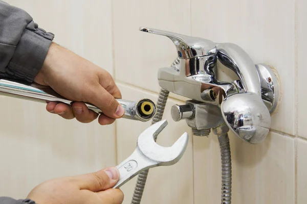 Plumber hands fixing water tap with spanner — Stock Photo, Image