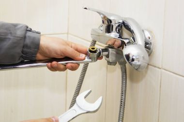 somun anahtarı ile tesisatçı eller su giderme dokunun