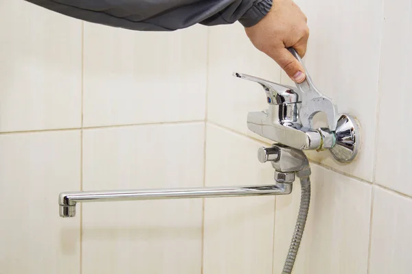 Plumber hands fixing water tap with spanner — Stock Photo, Image