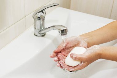 Elleri sabunla yıkamak vincin altında suyla