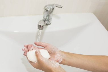 Elleri sabunla yıkamak vincin altında suyla
