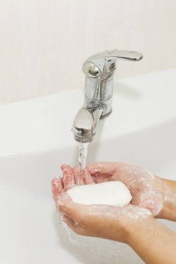 Elleri sabunla yıkamak vincin altında suyla