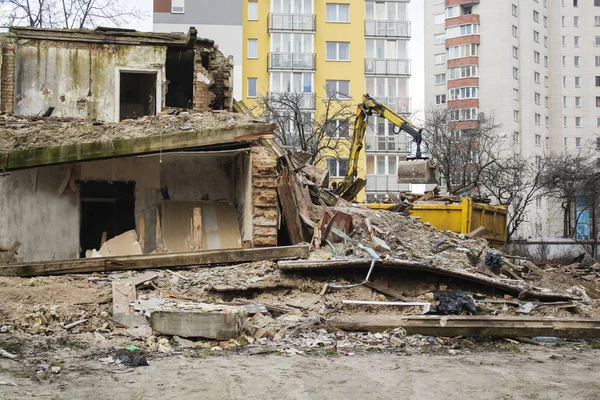 Η μπουλντόζα κατεδαφίστηκε το παλαιό κτήριο στο φόντο των νέων κατοικιών. — Φωτογραφία Αρχείου