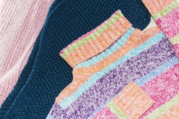 Swetry z wełny. Stos dzianin odzieżowych na drewnianym tle, swetry, dzianiny, miejsce na tekst. — Zdjęcie stockowe