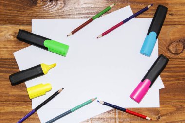 Beyaz kağıdın bir ahşap, yakın, açayım kalemler, işaretçileri, kalem. Üstten Görünüm.