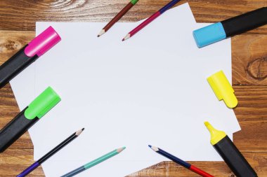 Beyaz kağıdın bir ahşap, yakın, açayım kalemler, işaretçileri, kalem. Üstten Görünüm.