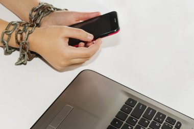 Demir zinciri birlikte elleri ve akıllı telefon - cep telefonu bağımlılığı kavramı bağları.