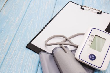 Beyaz bir parça kağıt, arka planda tansiyon ölçme için donatım