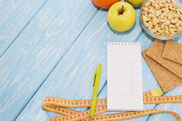 Здоровая диета, фитнес и потеря веса концепция, яблоко, блокнот, карандаш, измерительная лента на столе. Вид сверху . — стоковое фото