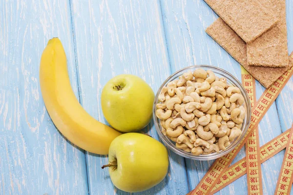 Здоровый завтрак. Орехи кешью в белой миске. Зеленое яблоко, банан. Юмор. Мужская потенция . — стоковое фото