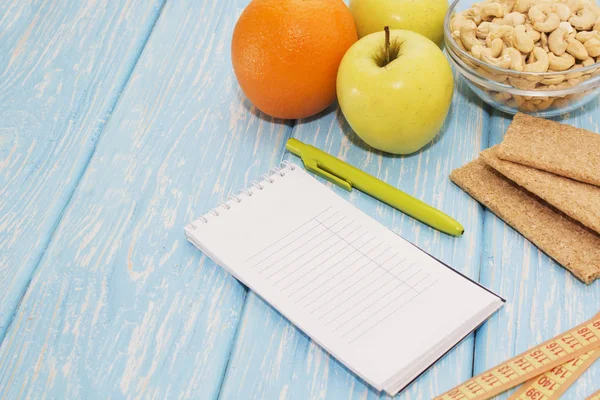 Здоровая диета, фитнес и потеря веса концепция, яблоко, блокнот, карандаш, измерительная лента на столе. Вид сверху . — стоковое фото