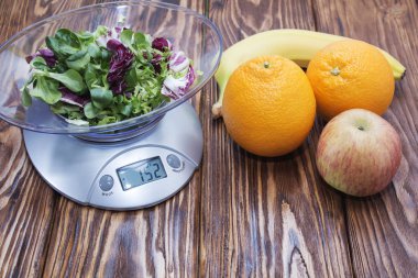 Yeşil marul mutfak ölçekte yaprakları. muz elma portakal ahşap tablo