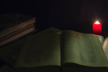 mum ve İncil'in geceleri ahşap arka plan üzerine bir kitap