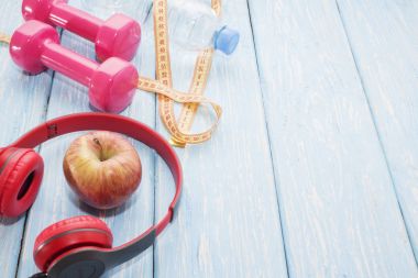 Ahşap tezgah, kopya alanı, diyet ve sağlıklı gıda kavramı dumbbells ile taze meyve. Kulaklık ve telefon. Müzik spor.