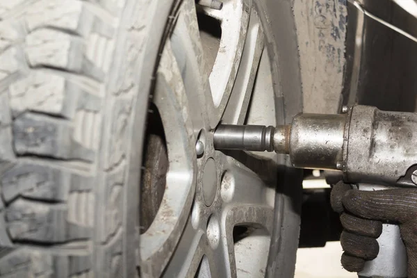 Kfz-Mechaniker wechseln Reifen auf Rädern in der Garage aus. Mechaniker Arbeiter beim Einbau von Autorädern bei Wartungsarbeiten. Reifenmontagekonzept — Stockfoto
