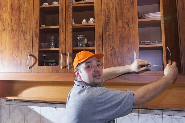 Young man assembling kitchen furniture — Stock Photo, Image