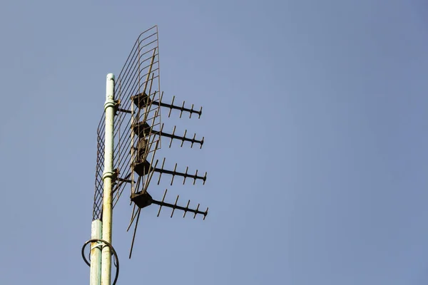 Antena celular no telhado do edifício contra o céu azul — Fotografia de Stock