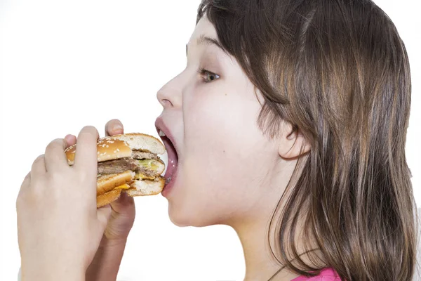 Портрет красивої дівчини, підлітка і школярки, що тримає гамбургер на білому тлі . — стокове фото