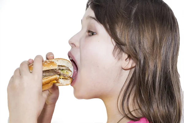 Portrait of a beautiful girl, teenager and schoolgirl, holding a hamburger on a white background. — Stock Photo, Image