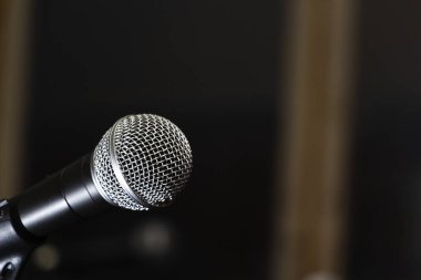 Sahnede karanlık bir arka planda mikrofon. Karaoke konsepti