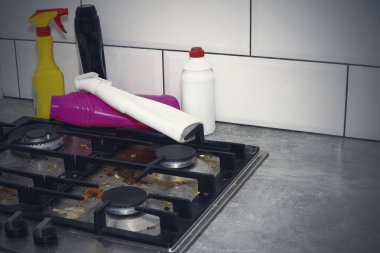 Kirli, gaz sobasının üst kısmı ve yiyecek parçaları. Ev temizliği.