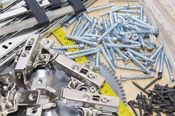 Schrauben, Möbelbestätigungen, Maßband liegen auf dem Tisch. Möbelproduktion — Stockfoto