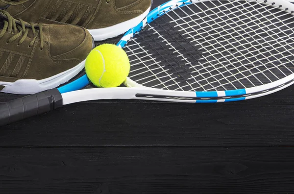 Tennis auf schwarzem Holzgrund. Laufschuhe, Tennisschläger, Ball, — Stockfoto
