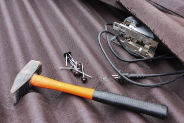 Çekiç ve çivi ile asfalt çatı zona arka plan yakından görünümü.