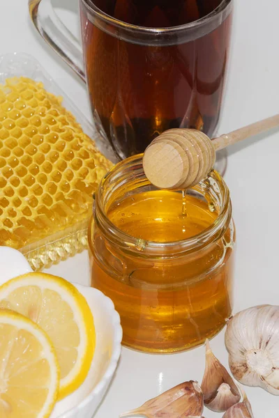 Honey on the background of honeycomb. Honey in a glass jar and honeycomb — Stock Photo, Image