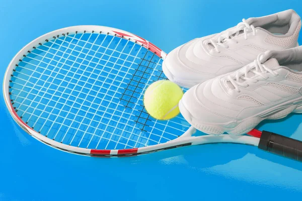 Tennisschläger mit Ball und Turnschuhen auf hellem Hintergrund. Fotografiert im Studio. — Stockfoto