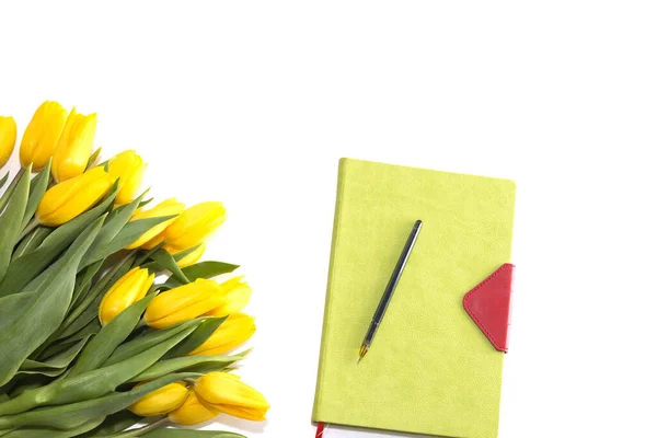 Tulipány kvetou a notepad pro poznámky na světle dřevěném bílém pozadí. Seznam dárků. — Stock fotografie