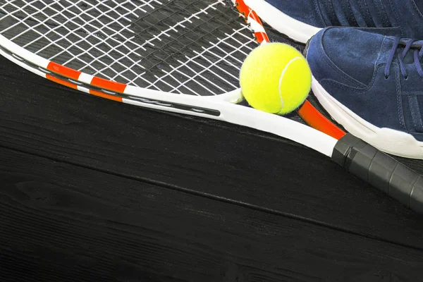 Τένις σε μαύρο ξύλινο φόντο. αθλητικά τρεξίματος, ρακέτα, μπάλα, — Φωτογραφία Αρχείου