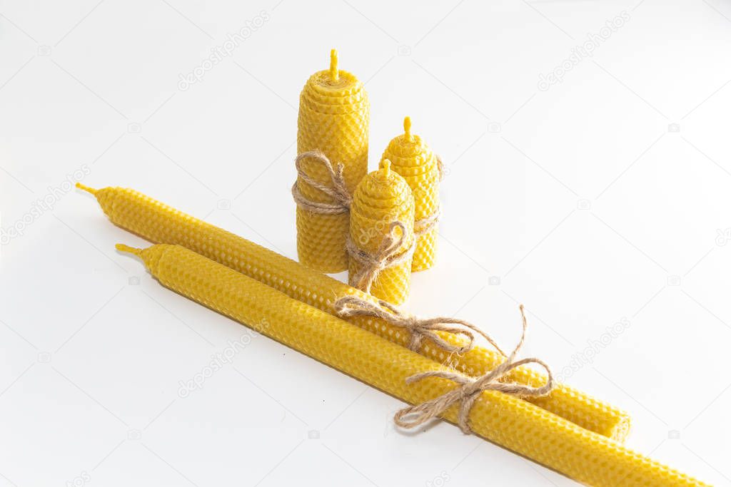 a group of wax candles tied with a rope. Natural wax. On light background.