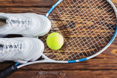 Tahta arka planda tenis raketi ve top. Stüdyoda Fotoğraflandı.