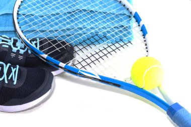 Toplu tenis raketi ve parlak bir arka planda spor ayakkabısı. Stüdyoda Fotoğraflandı.