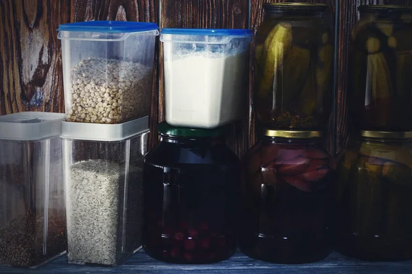 Багато скляних банок з консервованою їжею і зерновими на дерев'яній полиці — стокове фото