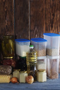 Bir sürü cam kavanoz, konserve yiyecek ve tahıllar ahşap bir rafta..