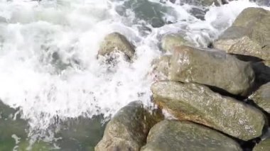 Deniz dalgası kayalıklarda kırılır, rüzgar ve su sesi.