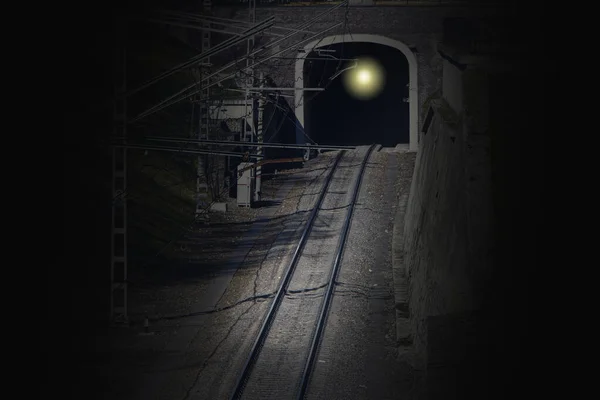 old railway tunnel crossing for trains, light at the end of the tunnel, exit from the tunnel