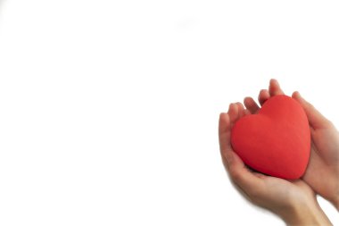 Kırmızı kalp, beyaz arka planda, kadınların ellerinde. Sağlığına dikkat et.