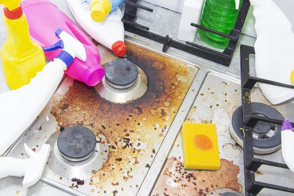 Dirty kitchen stove, empty and full bottles of detergents around. — Stock Photo, Image