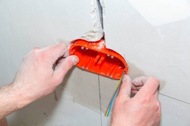 Yeni soketler takılıyor. Apartmanda tamirat var. elektrik tesisatı için duvardaki kablo çıkışı ve bağlantı kanalı.