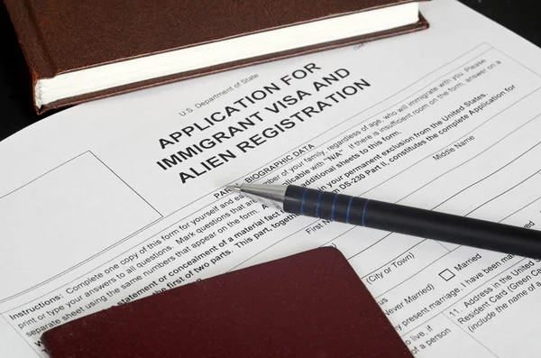 Kağıt Form ABD Göçmenlik vizesi siyah yüzeyinde yer alır.