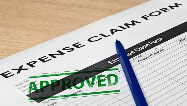 Expence claim form on a wooden surface — Stock Photo, Image