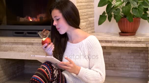 Menina segurando um tablet e senta-se no chão — Vídeo de Stock